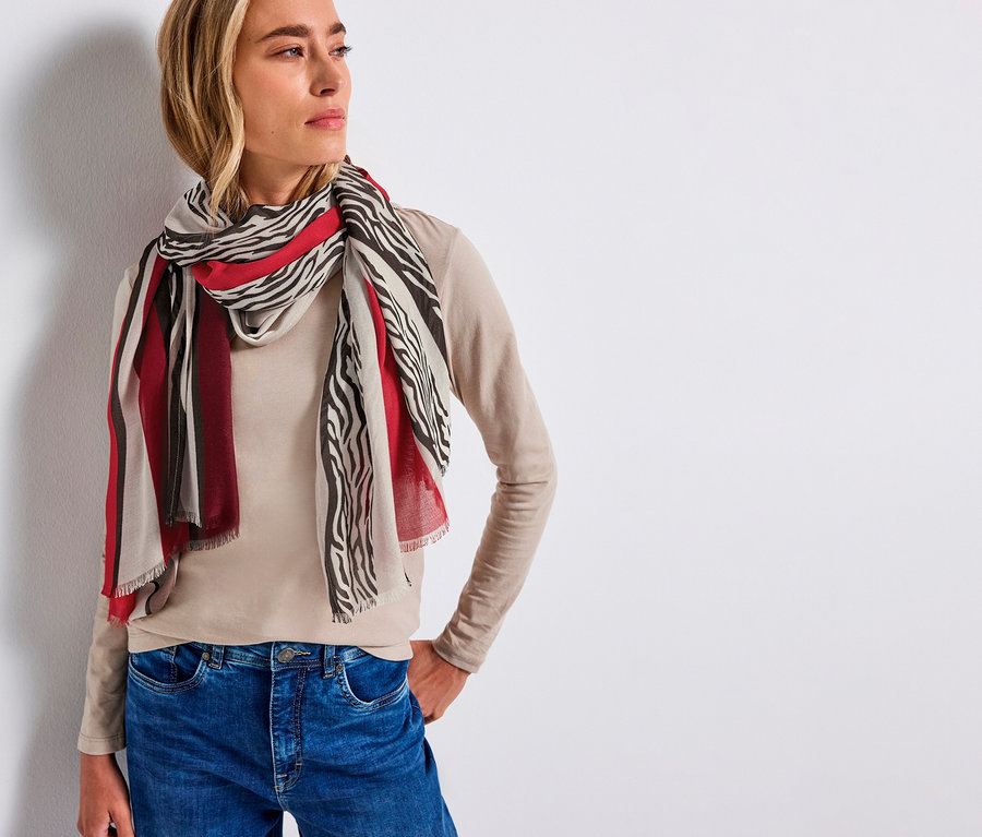 Nő visel egy Street One sálat modálból, zebra- és csíkos mintával.