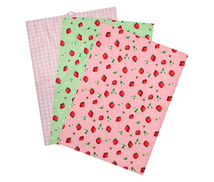 Három textil szalvéta: egy rózsaszín kockás, egy zöld eperrel és méhekkel, és egy rózsaszín eperrel és méhekkel.