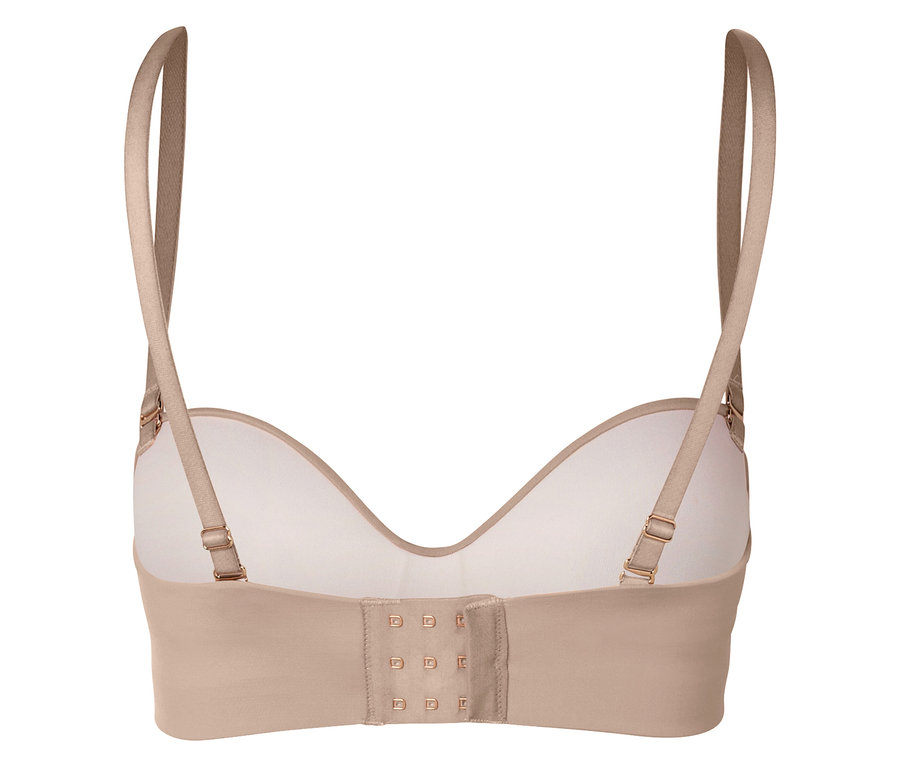 Egy bézs színű melltartó hátuljának közeli felvétele, állítható pántokkal és kapcsos zárással.