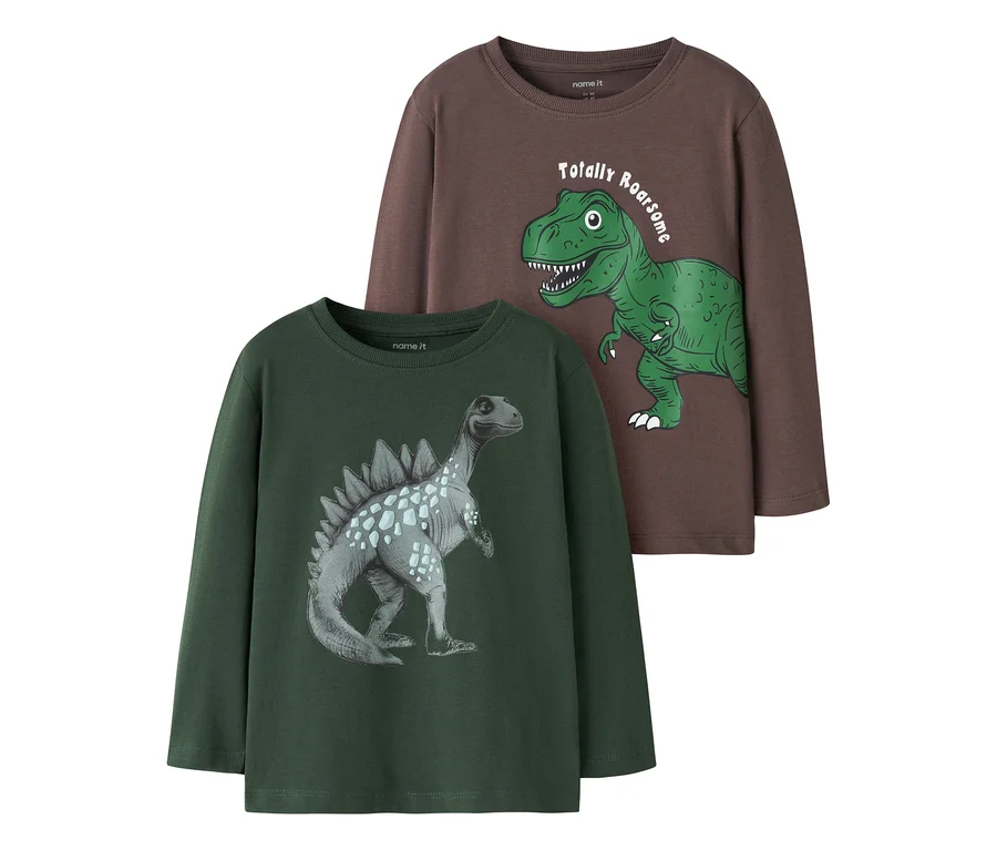 Sötétbarna hosszú ujjú póló zöld T-Rexszel és "Totally Roarsome" felirattal, egy sötétzöld hosszú ujjú pólón fekszik, melyen szürke dinoszaurusz látható.