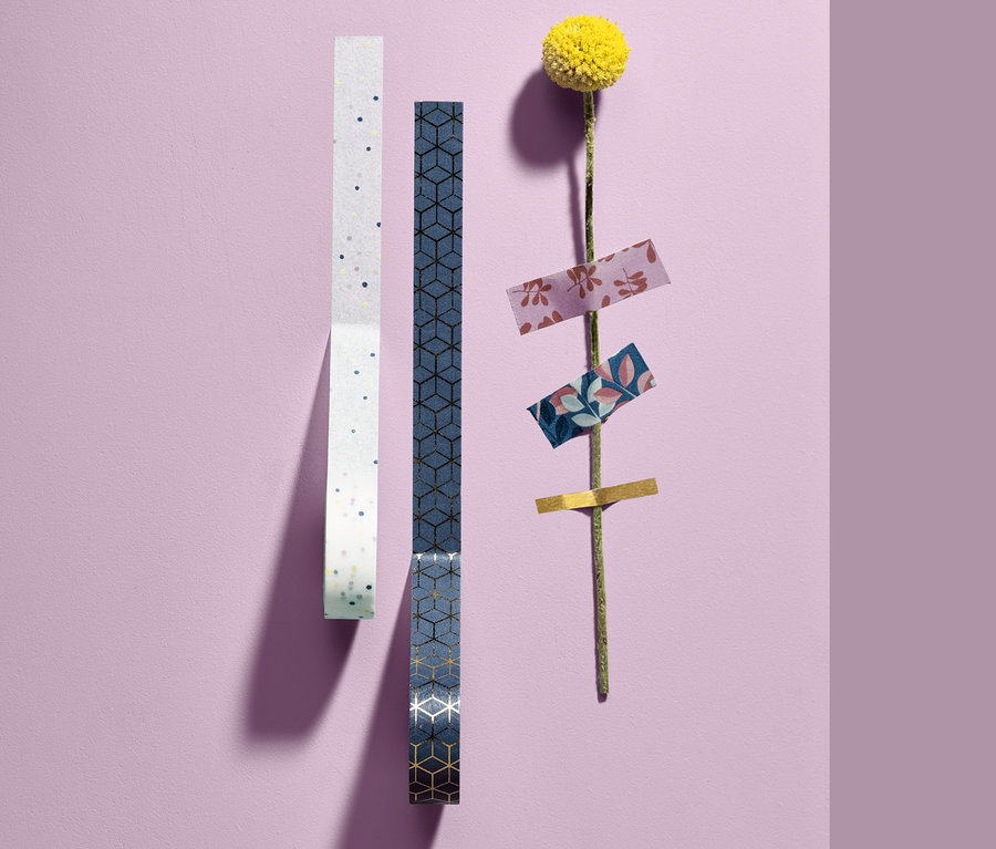 Két tekercs 10 dísz ragasztószalag szettből és egy sárga virág ragasztószalagokkal a száron.