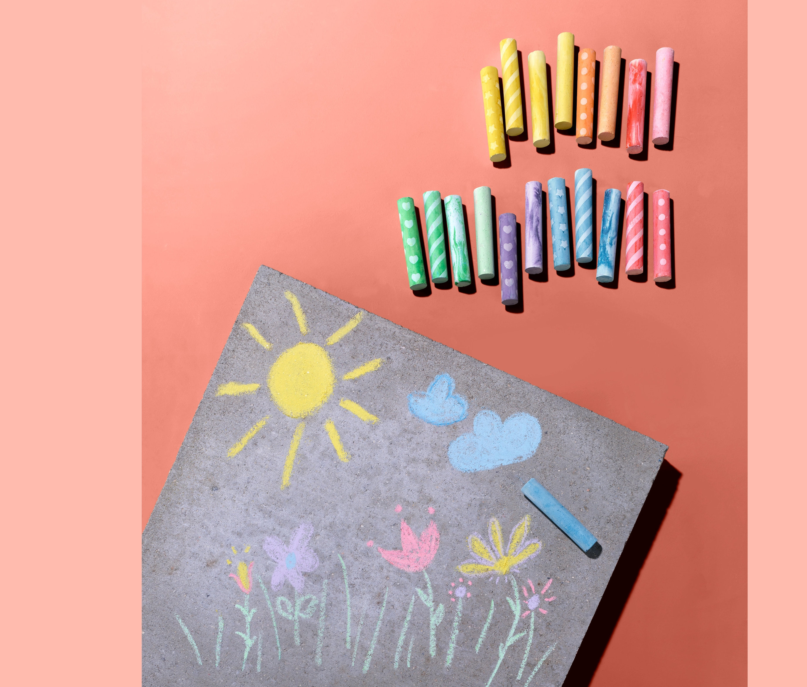 Nap, felhők és virágok rajzai krétával a járdán, 20 darabos színes kréta készlettel.