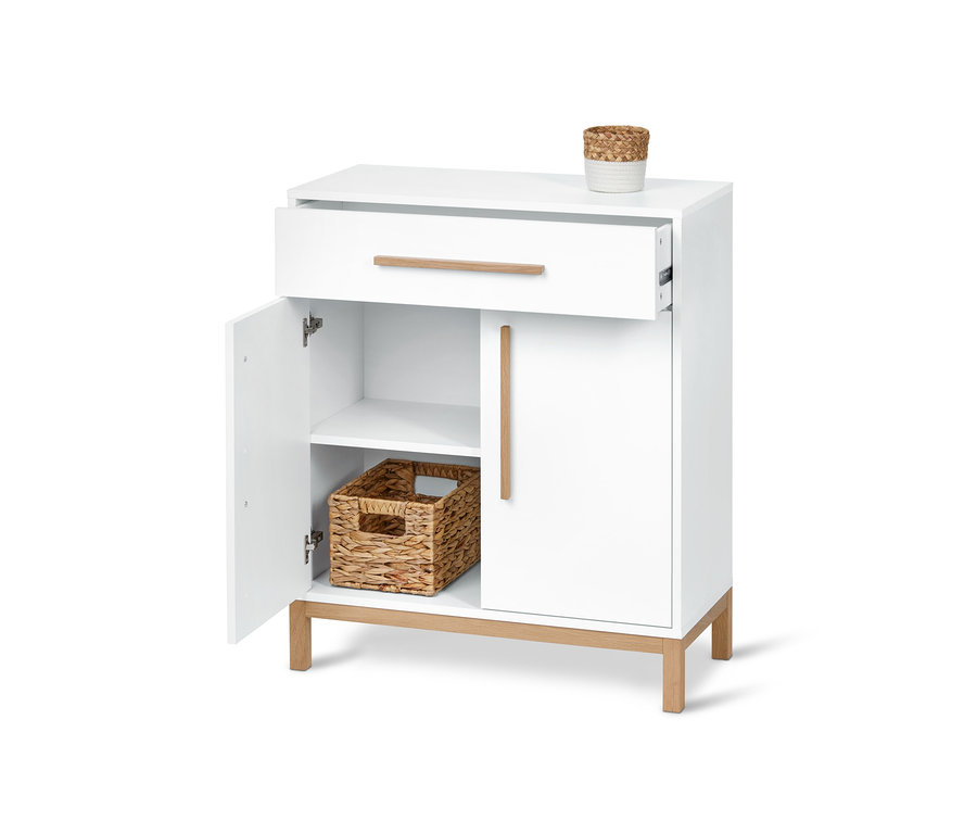 Fehér fürdőszobai komód nyitott fiókkal és ajtóval, belül fonott kosár.
