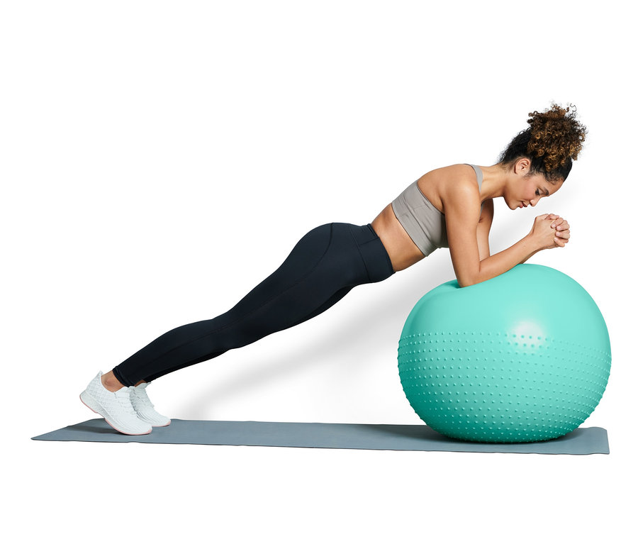 Nő plank gyakorlatot végez egy fitneszlabdán.