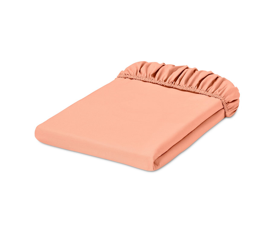 Egy összehajtott barack színű, normál méretű gumis perkál lepedő.