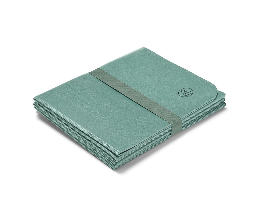 Egy összehajtogatott jógamatracot tart egy gumiszalag.