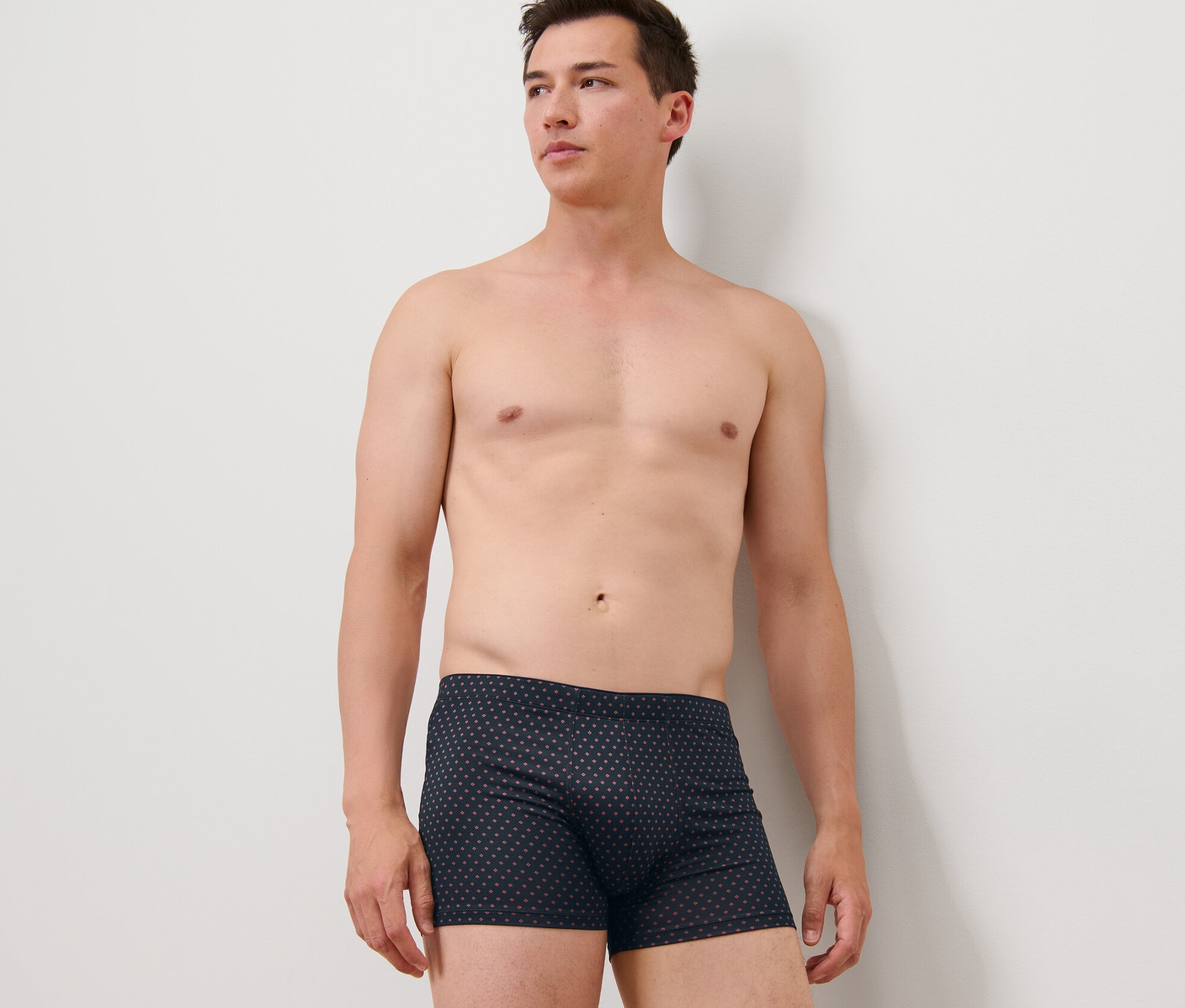 Férfi pózol egy 4 darabos mintás/sötétkék férfi mikroszálas boxeralsóban.