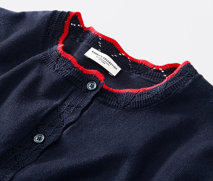 Egy sötétkék, azsúrmintás, női finomkötésű kardigán részlete.