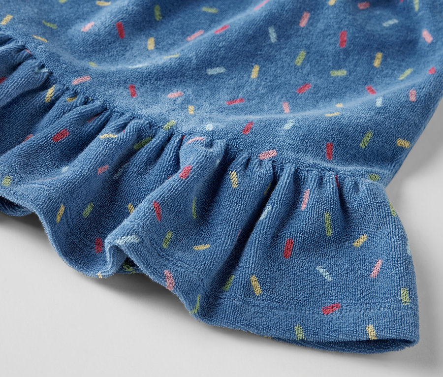 Egy frottírszoknya gyerekeknek részlete fodrokkal és színes nyomtatással.