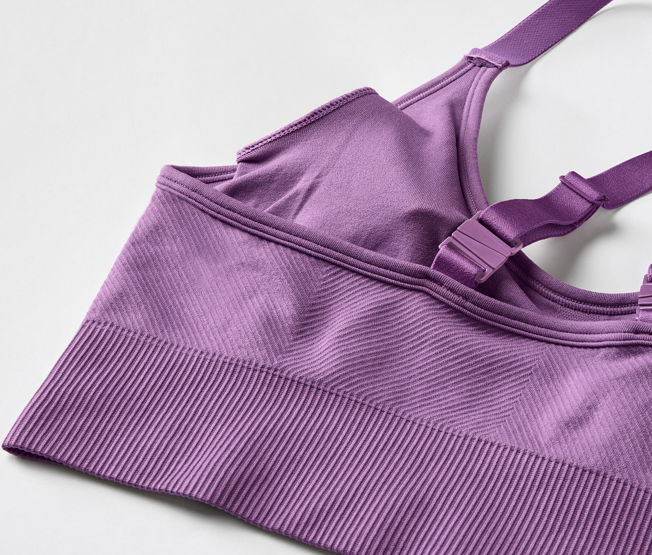 Lila sportmelltartó részlete, állítható pántokkal.