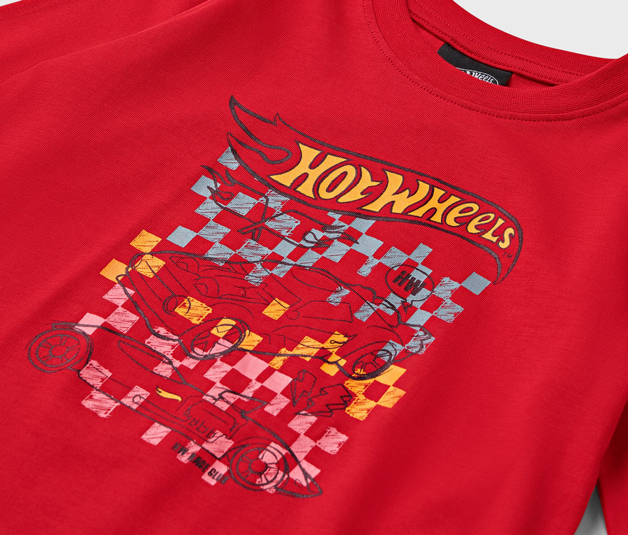 Egy piros póló részlete Hot Wheels mintával.