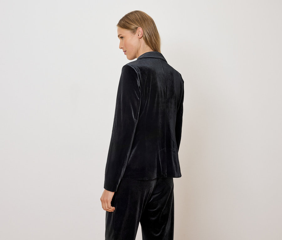 Nő visel bársony blézert és nadrágot.