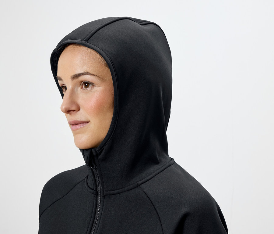 Barna hajú nő fekete kapucnis pulóvert visel.