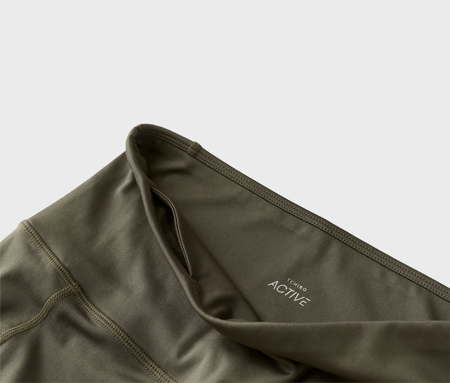 Közelkép egy olívazöld Tchibo Active leggingsről zsebbel.