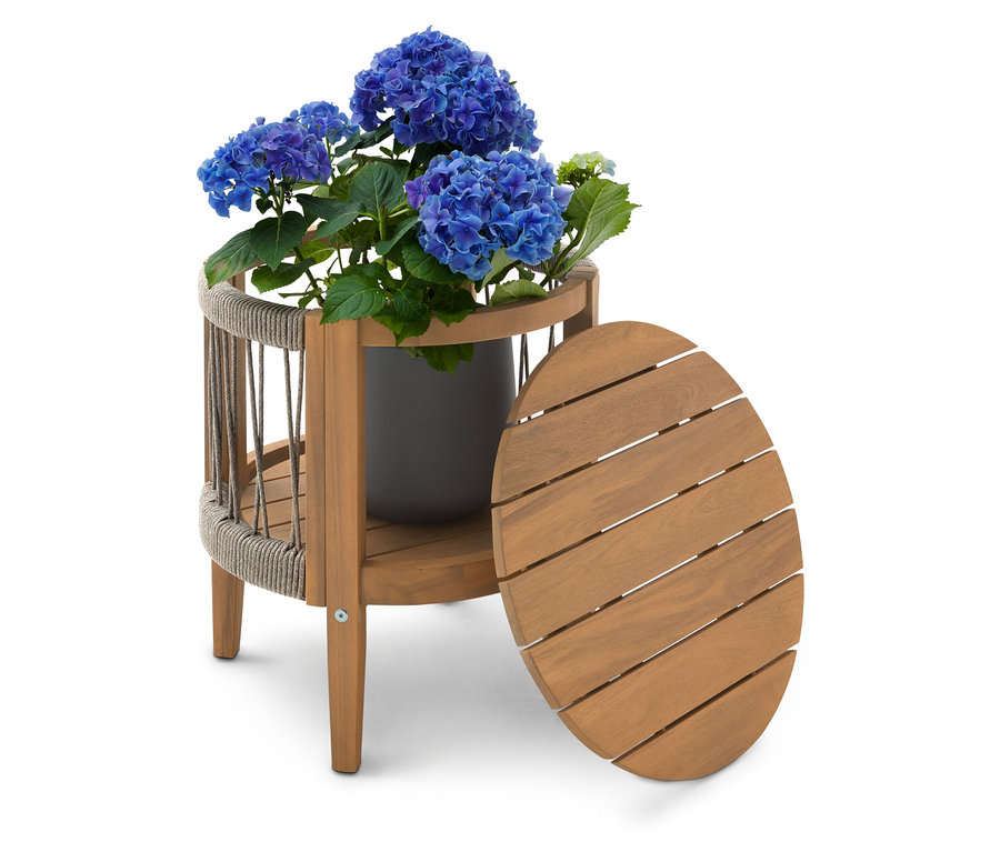 Kék hortenzia bokor szürke cserépben egy kétszintes fa asztalon, mellette egy ovális asztallappal.