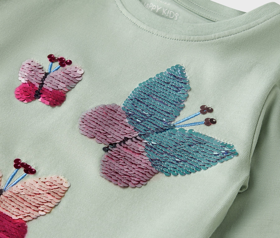 Világoszöld, hosszú ujjú póló flitteres pillangókkal.