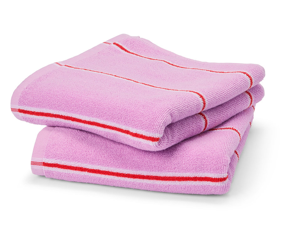 Három rózsaszín törölközőből álló halom piros és fehér csíkokkal.