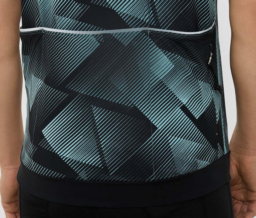 Egy fekete és türkiz geometrikus mintázatú kerékpáros mez hátuljának közeli képe.