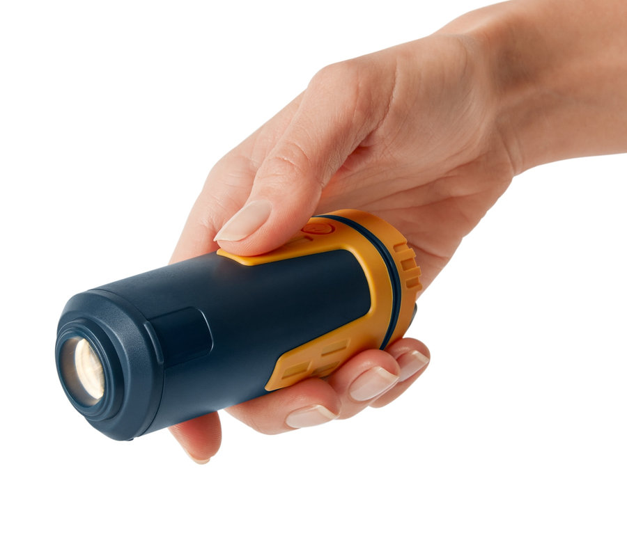 Egy kéz egy teleszkópos kempinglámpát tart.