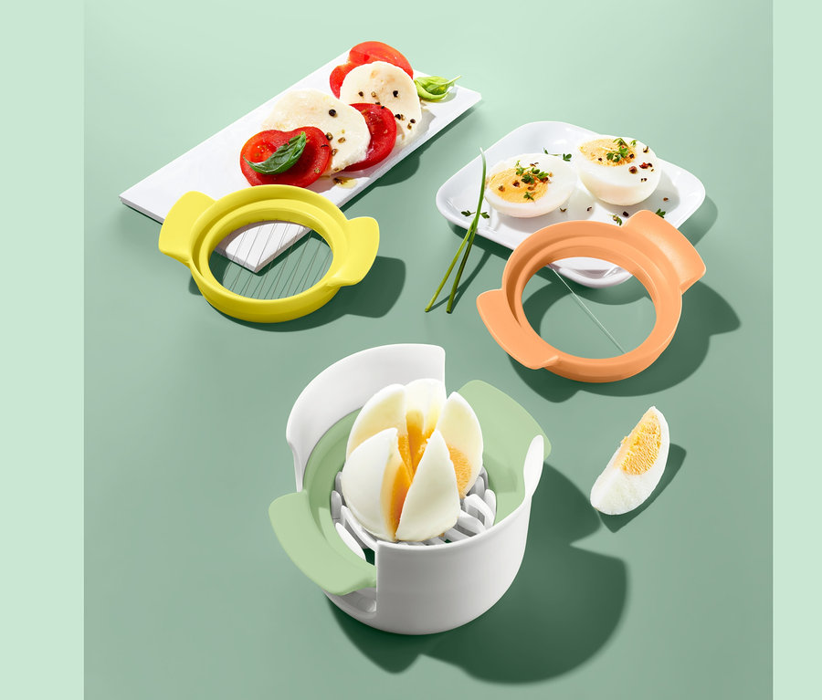 Egy 3 az 1-ben tojás- és mozzarellaszeletelő látható szeletelt mozzarellával, paradicsommal és tojással.