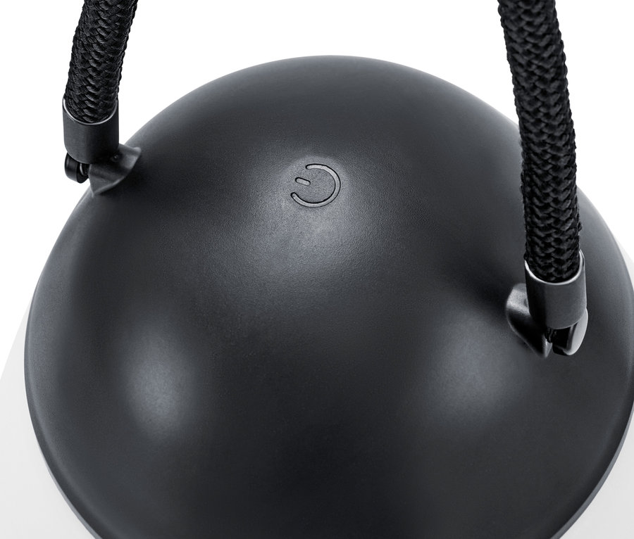 Egy LED-es akkus lámpa közeli képe további pótakkumulátorral, fekete felsőrésszel és zsinórral.