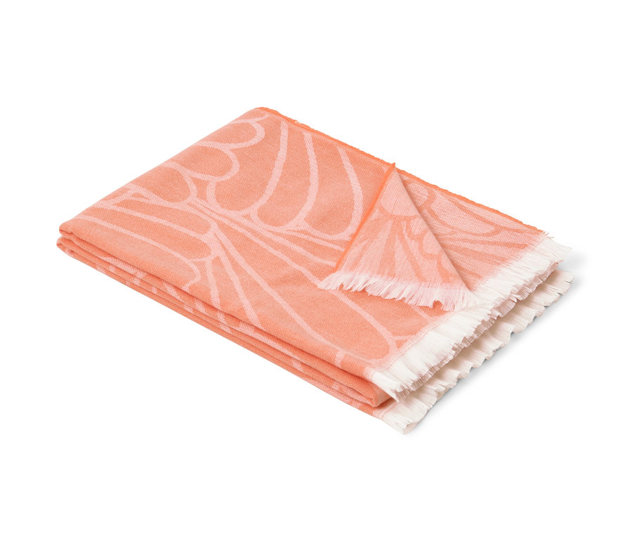 Összehajtott, narancssárga virágmintás, kétoldalas puha takaró, kagylós.