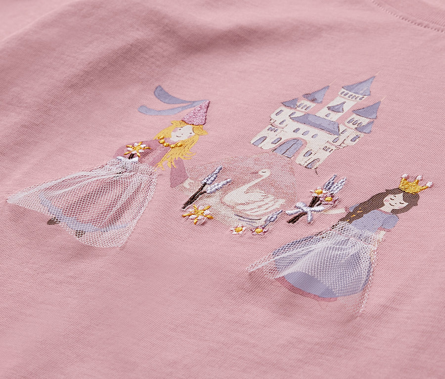 Egy rózsaszín, hercegnős, hosszú ujjú gyerekfelső részlete.