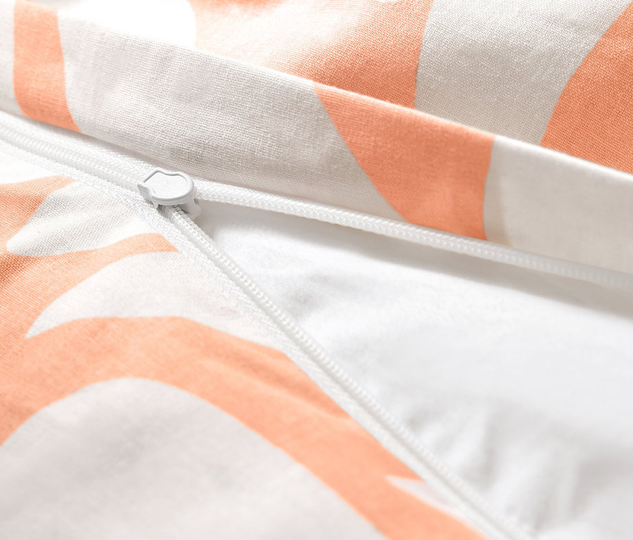 Közelkép a barackszínű, normál méretű renforcé ágynemű cipzárjáról.