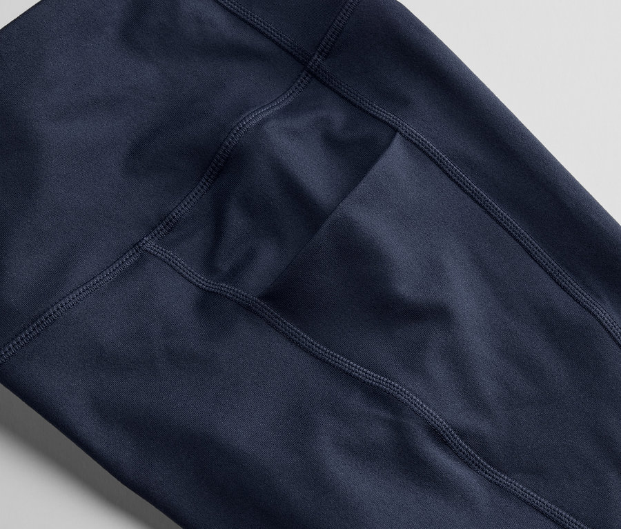 Közeli kép egy sötétkék, 3/4-es sportnadrágról, zsebbel.
