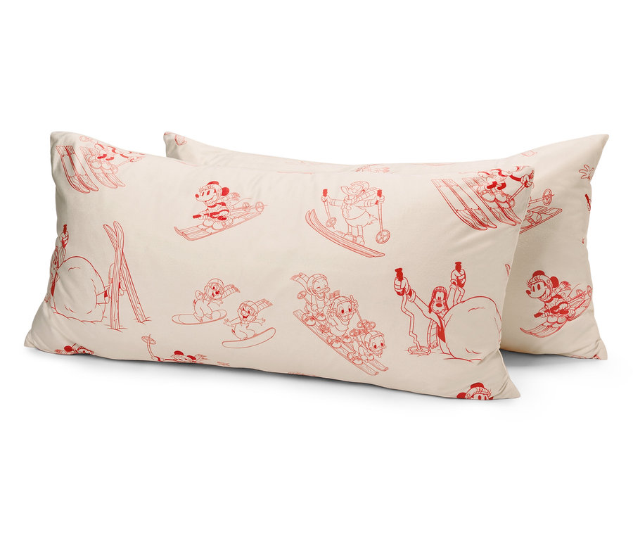 Két fehér párna piros rajzfilmfigurákkal, síelő egerekkel.