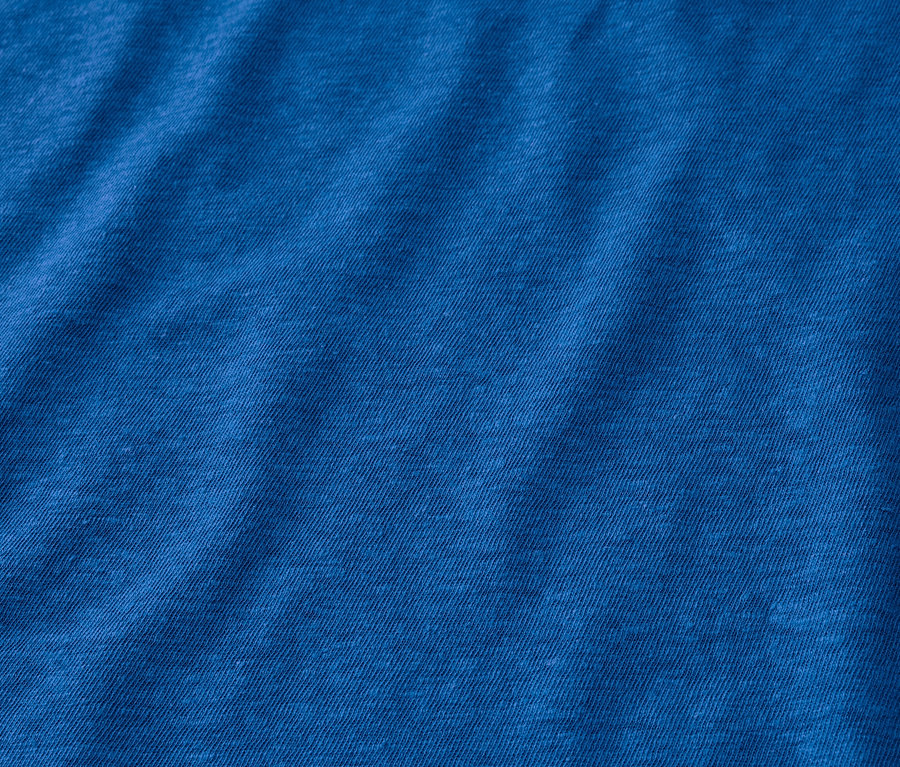 Egy kobaltkék színű, lenvászon keverékéből készült póló részlete.