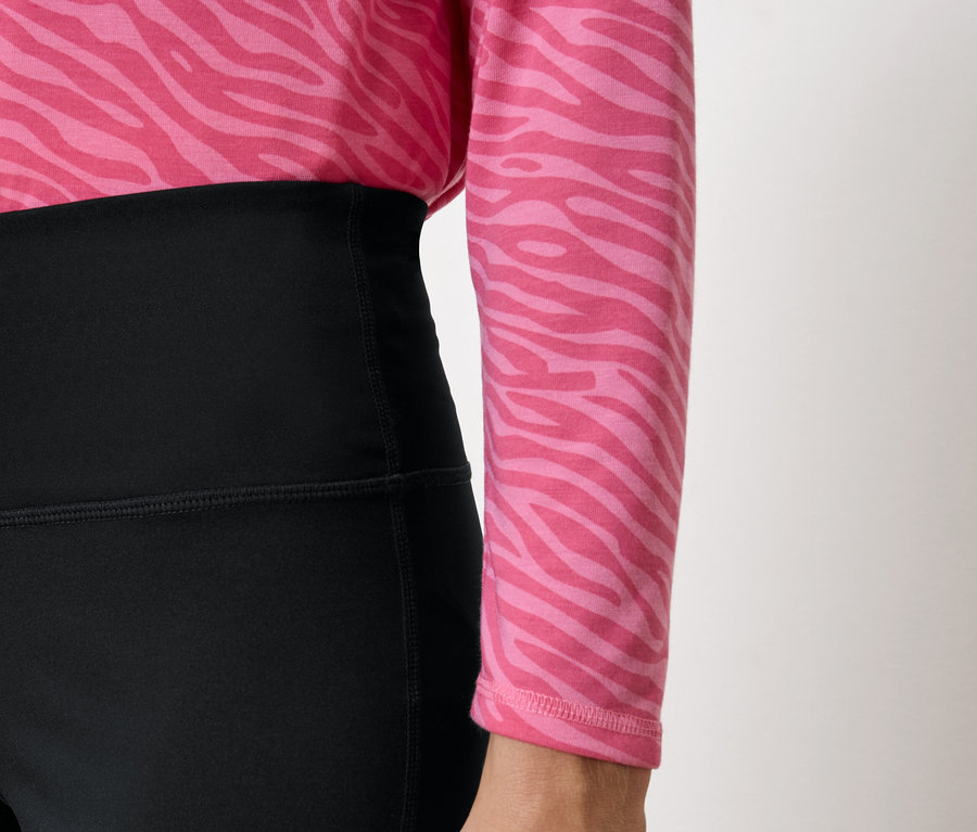 Magas derekú fekete leggings és rózsaszín, állatmintás felső.