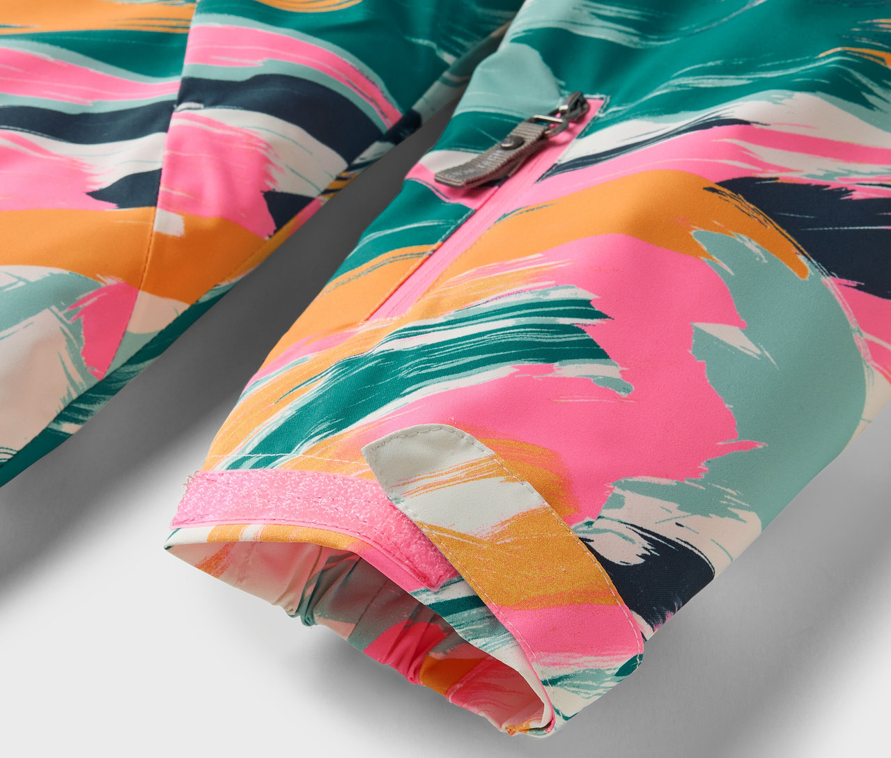 Egy színes, absztrakt mintás kabát részlete.