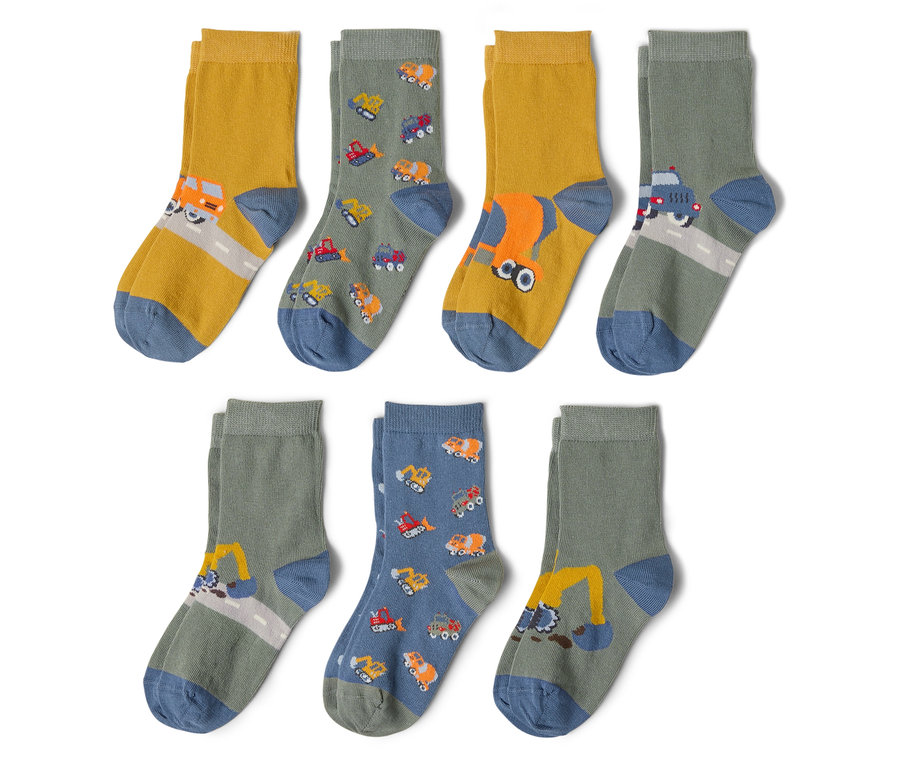 Hat pár zokni fekszik egy fehér háttéren. A zoknik különböző építőipari járművekkel vannak nyomtatva, mint például kotrógépek, teherautók és betonkeverők.