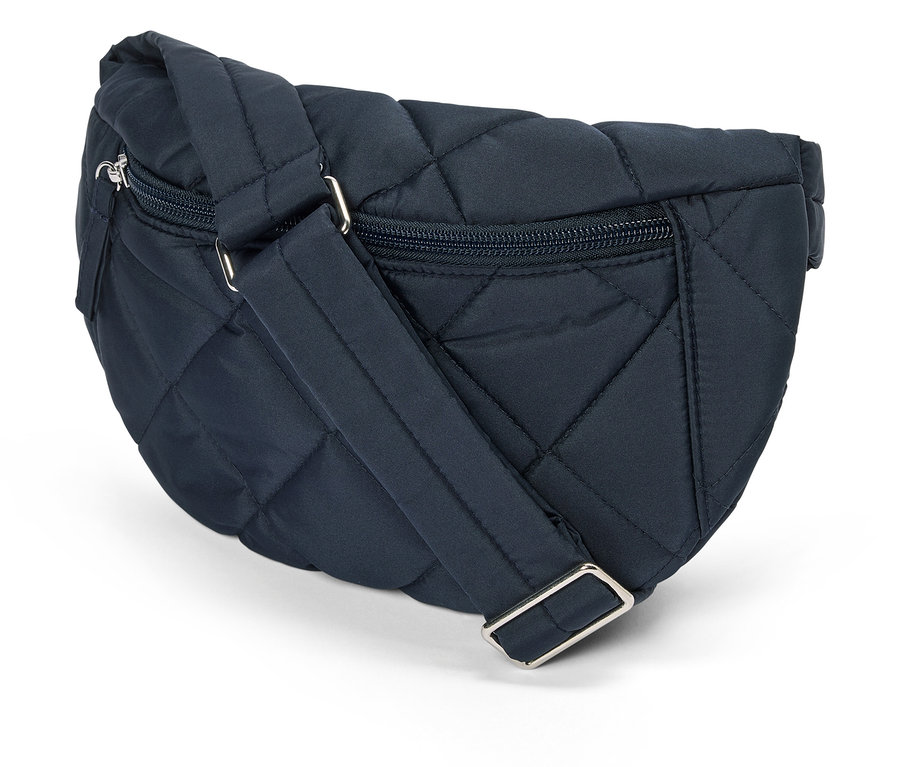 Egy tengerészkék, steppelt övtáska közeli képe ezüst cipzárral és állítható pánttal fehér háttér előtt.