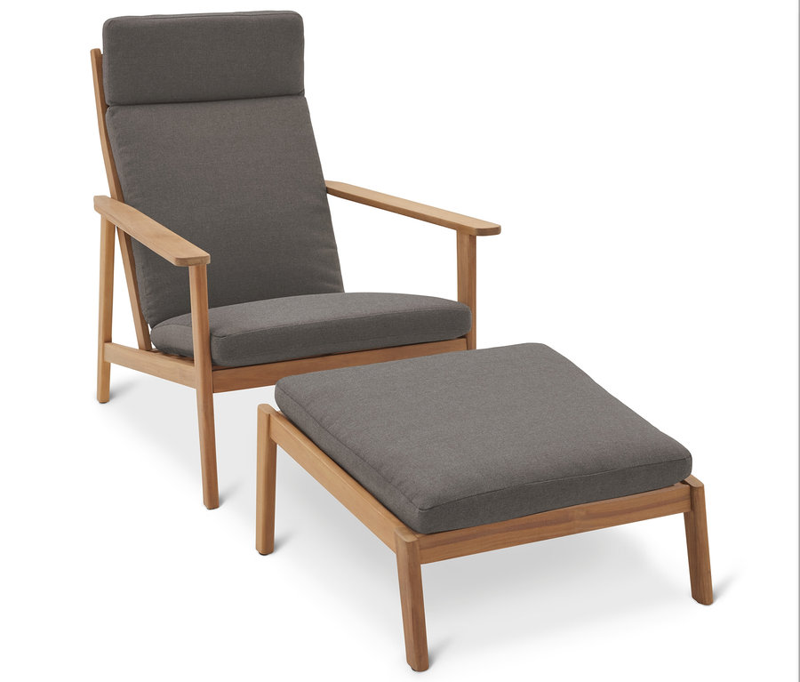 Egy szürke fotel a hozzáillő lábtartóval fehér háttér előtt.