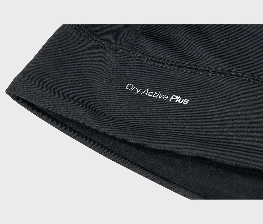 Fekete anyag közelképe fehér „Dry Active Plus” felirattal, látható varrással és puha belső béléssel.