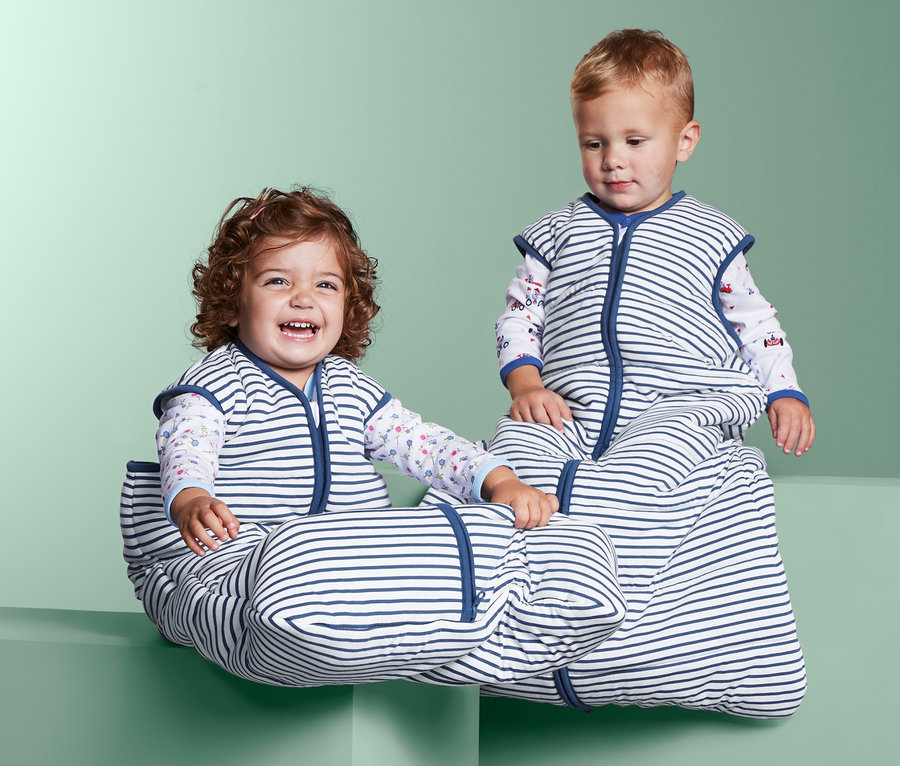 Gyerekek ülnek csíkos kisgyerek hálózsákban a blokkokon.