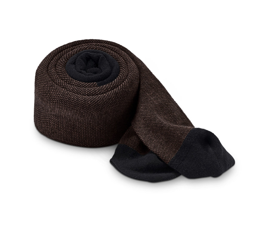 Egy barna, texturált harisnya feltekerve, fehér háttérrel.