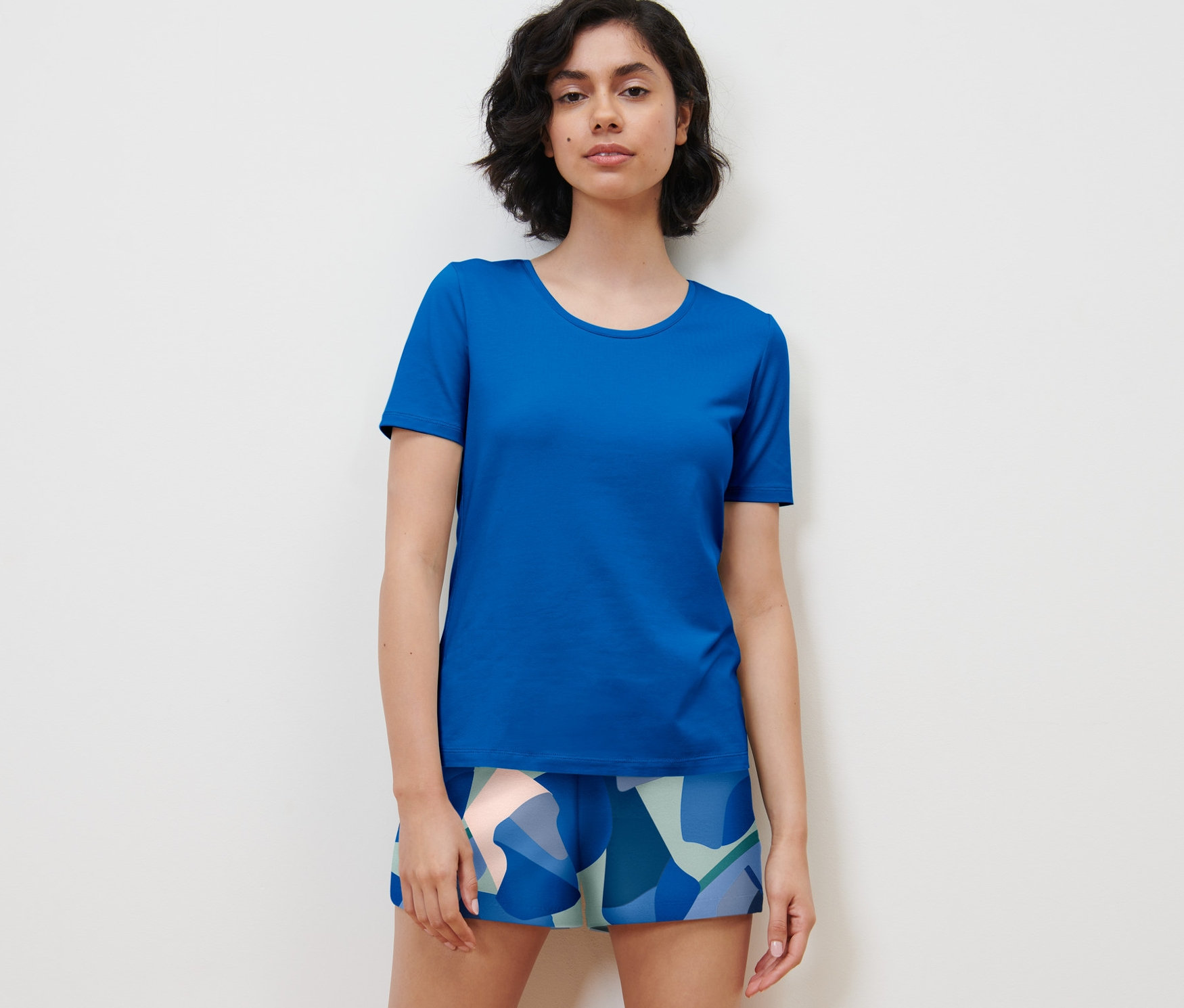 Nő mintás/kék rövidnadrágos pizsamát visel.