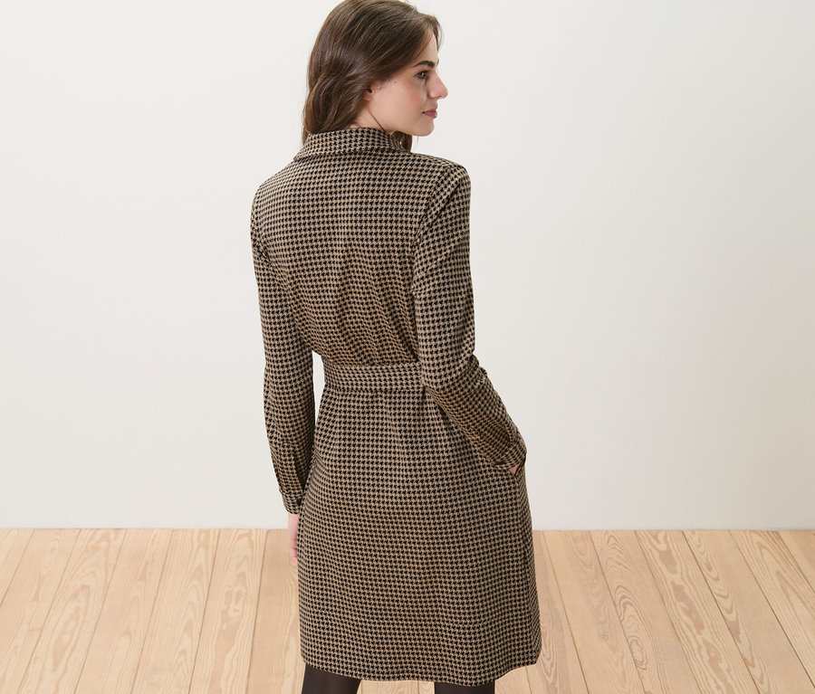 Nő visel egy tyúklábmintás jacquard ruhát.