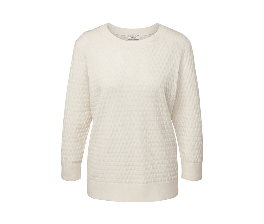 Egy törtfehér, mintás kötött pulóver.