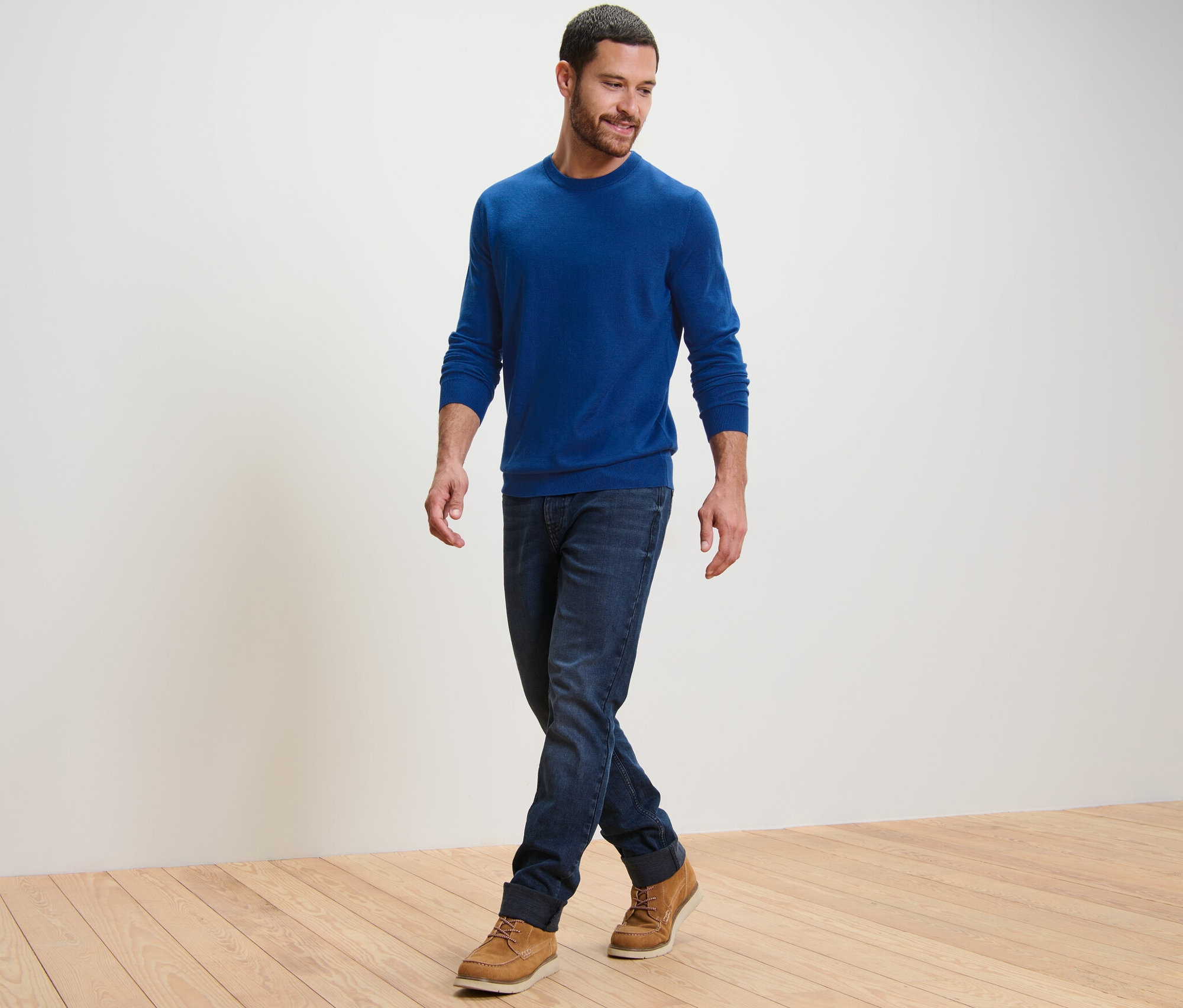 Férfi sétál, kék merinó gyapjú pulóvert visel.