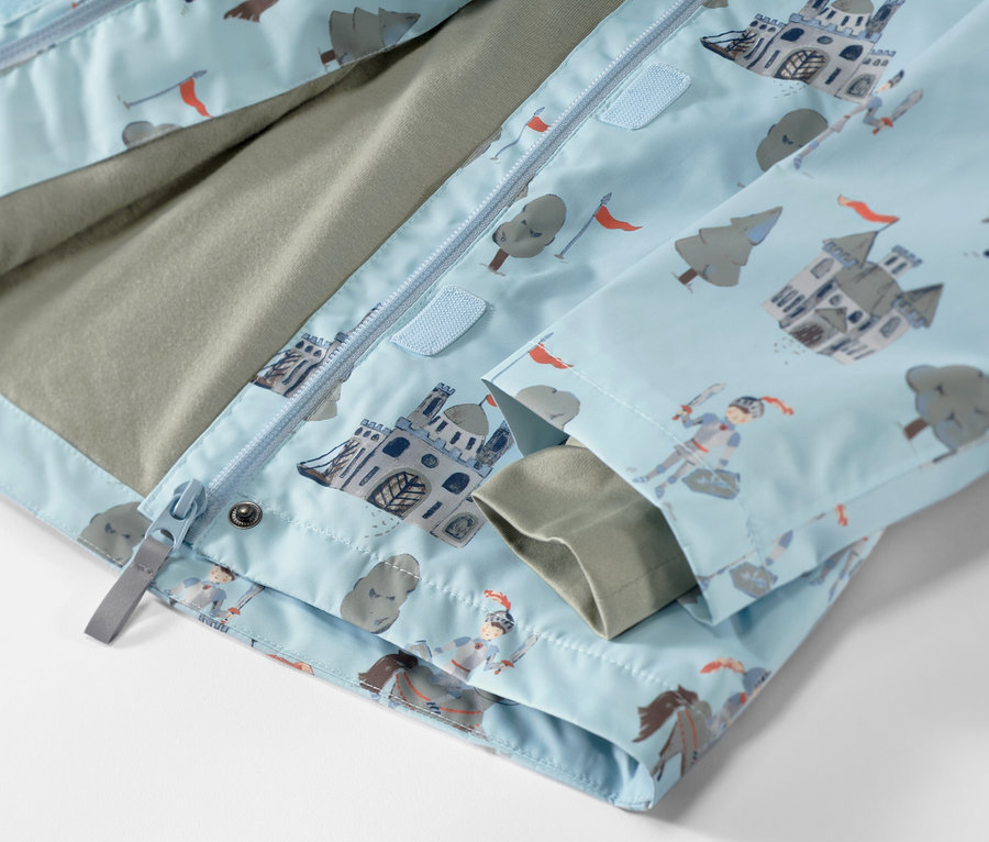 Részlet egy lovagmintás gyerek esőkabátról.