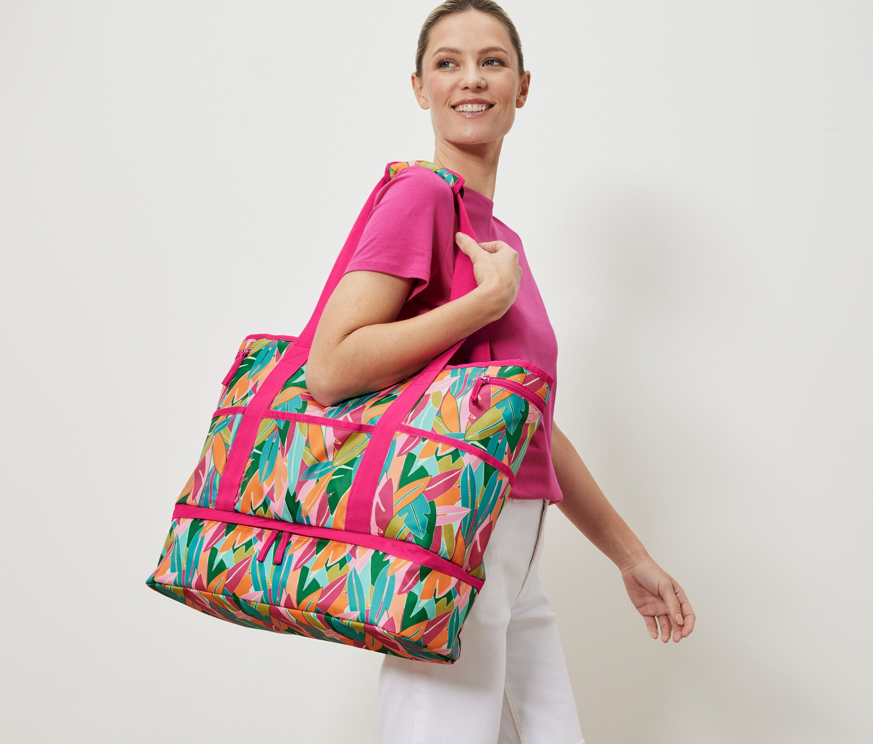 Nő mintás strandtáskát visz.