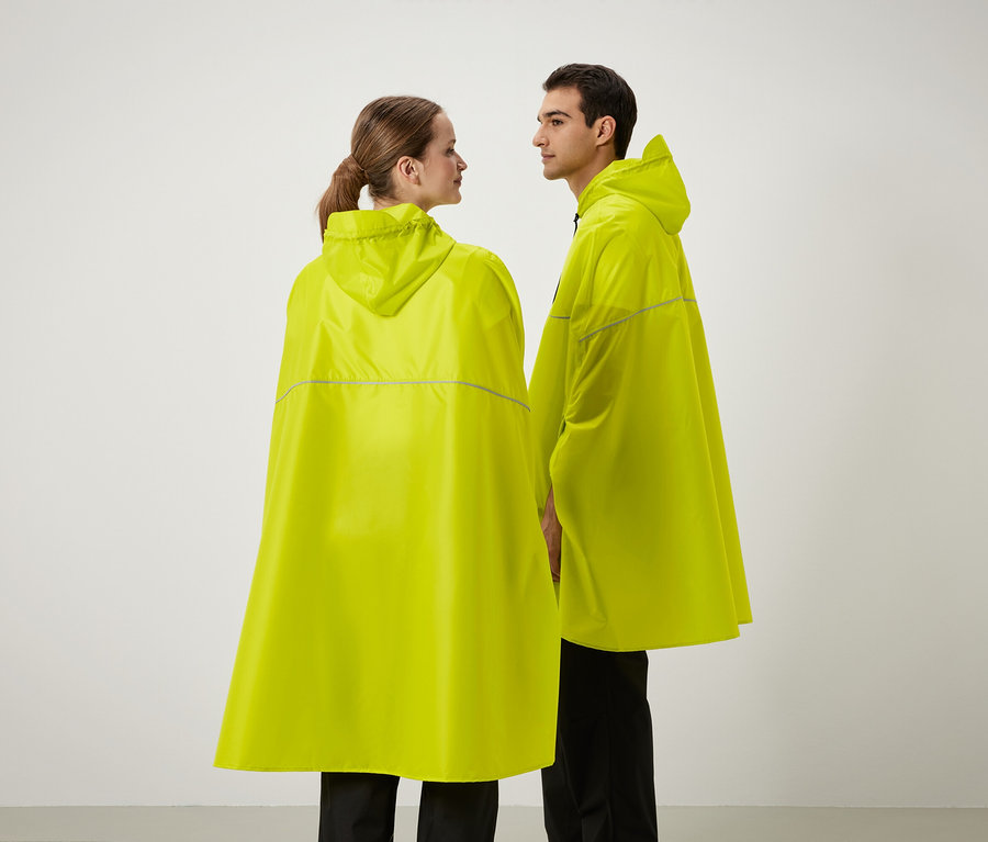 Két ember áll egymás mellett, sárga, kapucnis esőponcsót viselnek.