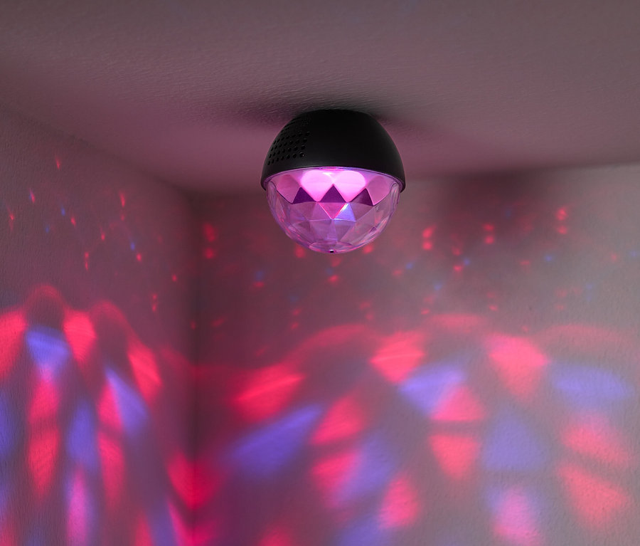 A mennyezetre egy diszkógömb van rögzítve, amely piros és kék fényeket vetít a szoba falaira.