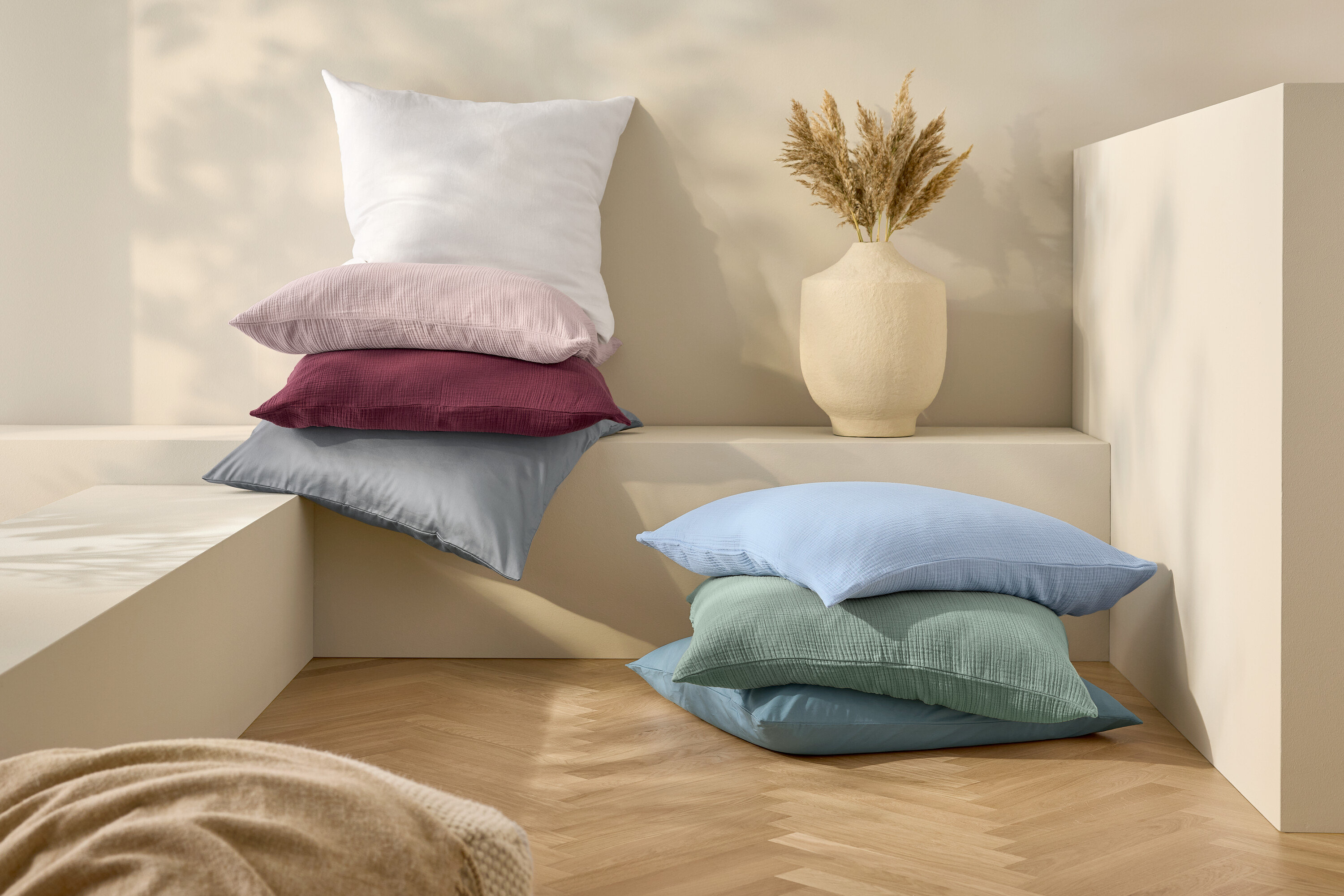 Egymásra rakott párnák és fehér, normál méretű lenvászon ágynemű.