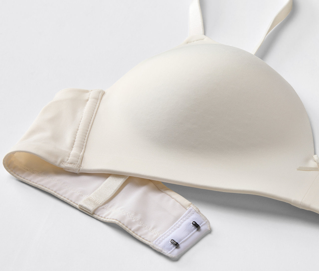 Egy fehér melltartó részletgazdag képe kapcsokkal.