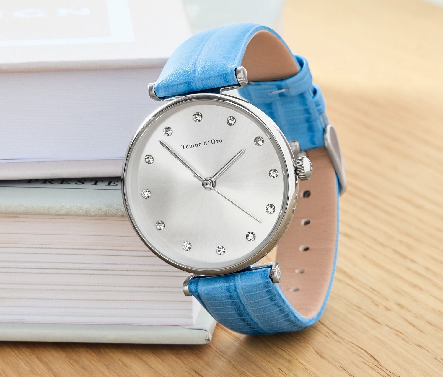 Egy női karóra bőrszíjjal a könyveken.